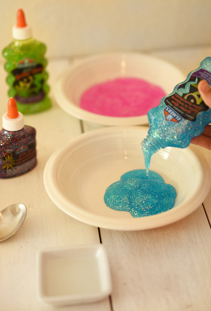 How To Make Rainbow Slime - Pour Blue Elmers Glitter Glue Into A Bowl - Cool and Easy Crafts for Kids and Teens - Ingredients and Step by Step Tutorial for Making Slime At Home - Cheap DIY Projects for Teens and Teenagers - Girls and Boys Love Making Slime